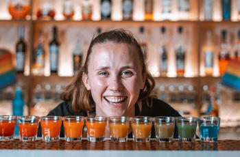 A set of rainbow shots with bartender