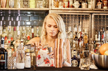 blonde beartender preparing a cocktail