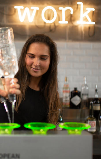 Student of the bartending course preparing cocktails with a lot of accuracy