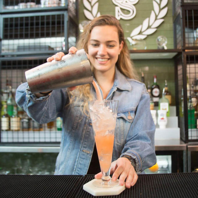 student pouring cocktail