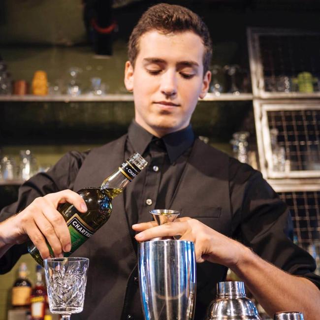 young professional bartender pouring