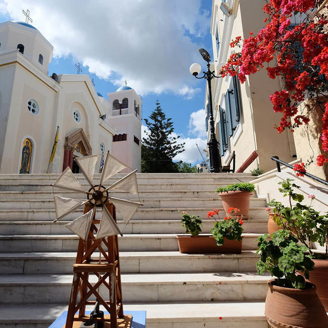 white building and steps with flowers in kos