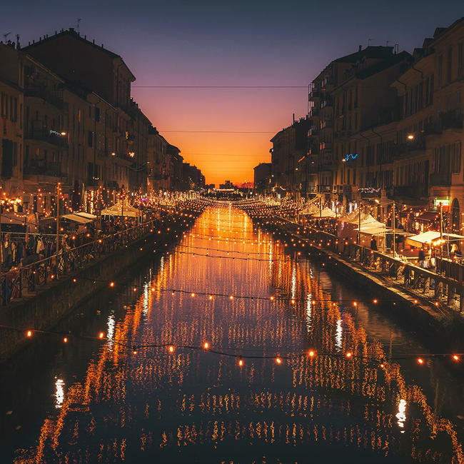milan canals dimly lit by string lights at sunset