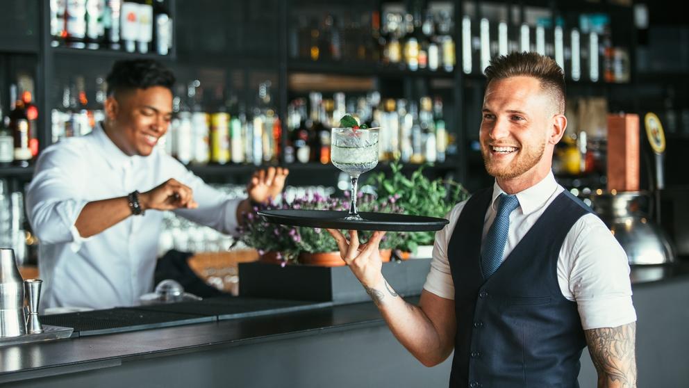 bartender holding tray with cocktail
